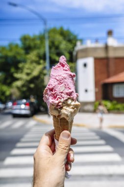 Elde dondurma. Sıcak bir yaz gününde sokağın arka planında dondurmalı gözleme külahı. Sokak yemekleri, tatlılar, tatlı konsepti. Yüksek kalite fotoğraf