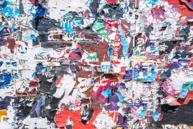 Torn paper collage background on an old poster on a street wall. Texture and surface of torn paper. High quality photo