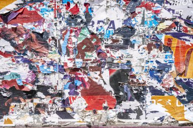 Torn paper collage background on an old poster on a street wall. Texture and surface of torn paper. High quality photo