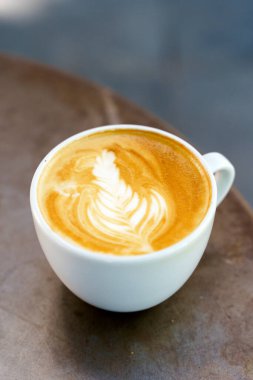Kafedeki bir masada bir fincan cappuccino kahvesi. Sabahları kahvaltıda seramik bardakta sıcak kahve içerim. Yüksek kalite fotoğraf