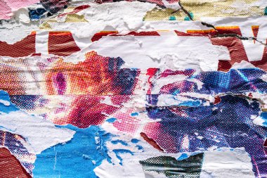 Torn paper collage background on an old poster on a street wall. Texture and surface of torn paper. High quality photo