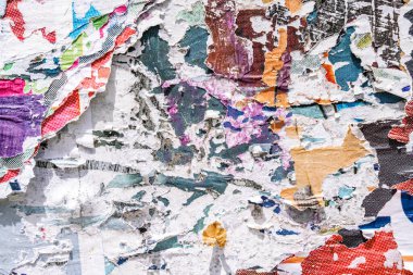 Torn paper collage background on an old poster on a street wall. Texture and surface of torn paper. High quality photo