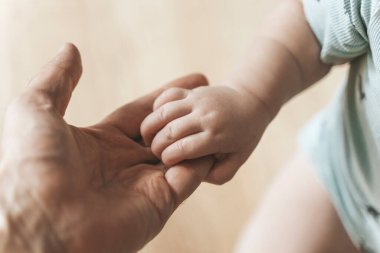 Bebek eli. Baba şefkatle kucaklıyor ve yeni doğan bebeğin küçük elini seviyor. Yeni bir hayat, ebeveyn koruması, bakım, sevgi, çocuk ve bebek sağlığı. Yüksek kalite fotoğraf