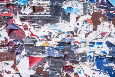 Torn paper collage background on an old poster on a street wall. Texture and surface of torn paper. High quality photo