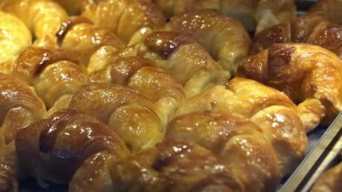 Bir pastanenin tezgahında ve fırında mini kruvasan hamur işleri. Yemek, tatlı geçmişi. Yüksek kaliteli FullHD görüntüler