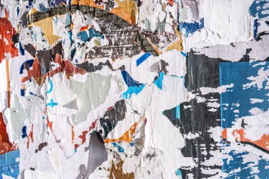 Torn paper collage background on an old poster on a street wall. Texture and surface of torn paper. High quality photo