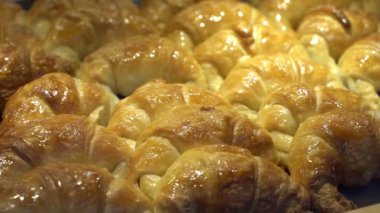 Bir pastanenin tezgahında ve fırında mini kruvasan hamur işleri. Yemek, tatlı geçmişi. Yüksek kaliteli FullHD görüntüler