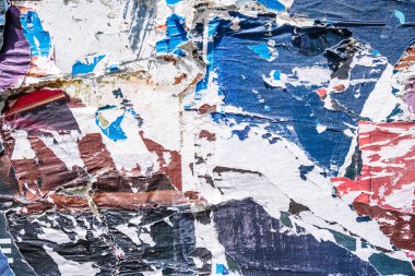 Torn paper collage background on an old poster on a street wall. Texture and surface of torn paper. High quality photo