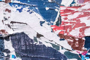 Torn paper collage background on an old poster on a street wall. Texture and surface of torn paper. High quality photo