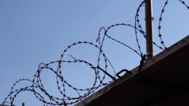 Fence with barbed wire against the sky. Crime, imprisonment, border, prison concept. High quality FullHD footage
