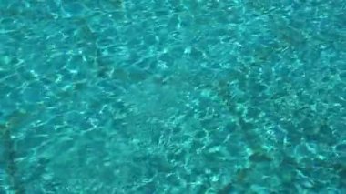 Mavi su havuzu geçmişi. Berrak turkuaz su, dalgalar ve güneş yansımaları. Yaz, rahatlama konsepti. Yüksek kaliteli FullHD görüntüler