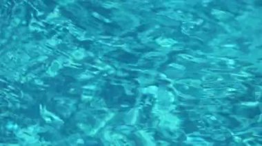 Mavi su havuzu geçmişi. Berrak turkuaz su, dalgalar ve güneş yansımaları. Yaz, rahatlama konsepti. Yüksek kaliteli FullHD görüntüler