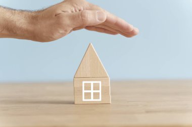 Ev ve emlak sigortası konsepti. Temiz bir arka planda ahşap ev modeli. Fikir, ev ve gayrimenkul kavramı. Yüksek kalite fotoğraf