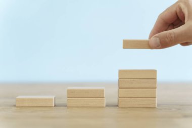 Büyüme, hedef, kendini beğenmişlik konsepti. Temiz bir zeminde tahta küplerin büyümesi. İş, ekonomi, strateji fikri. Yüksek kalite fotoğraf