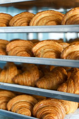 Fırında kruvasan. Pasta dükkanında hamur işi pişirmek. Fransız kruvasanları yaklaşıyor. Yüksek kalite fotoğraf