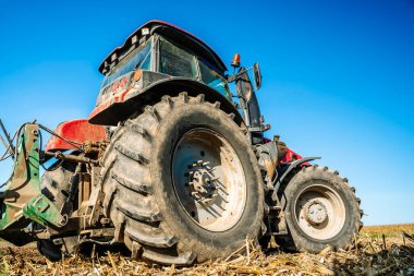Traktör sahada. Tarım makineleri. Hasattan sonra tarla ve ekin ekerken tarım traktörü. Yüksek kalite fotoğraf
