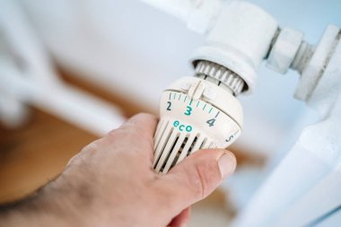 Radyatör termostatı ve el. Kışın ısıtma evi. Isıtma kavramından tasarruf ediyoruz. Yüksek kalite fotoğraf