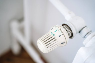 Radyatör termostatı ve el. Kışın ısıtma evi. Isıtma kavramından tasarruf ediyoruz. Yüksek kalite fotoğraf