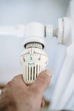 Radyatör termostatı ve el. Kışın ısıtma evi. Isıtma kavramından tasarruf ediyoruz. Yüksek kalite fotoğraf