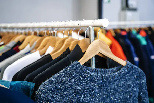 Second hand vintage clothes in a store on sale. Fashionable European used retro jeans, t-shirts, dresses, pants and accessories. Recycling and life extension for clothes concept. High quality photo