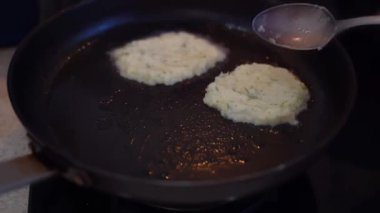 Patates krepleri kızartma tavasında kızartılır. Geleneksel patates yemeği. Vejetaryen kızartması. Yüksek kaliteli FullHD görüntüler