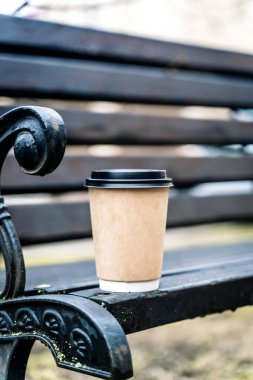 Parktaki bankta götürmek için bir fincan kağıt kahve. Yüksek kalite fotoğraf