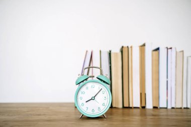 Kitaplar ve çalar saat okul ya da üniversite sınıfında bir masanın üzerinde. Eğitim, konsept eğitimi. Yüksek kalite fotoğraf