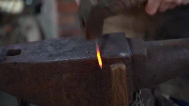 Demirci bir demircide örsün üzerinde çalışıyor. Sıcak metal dövmesi. Yüksek kaliteli FullHD görüntüler