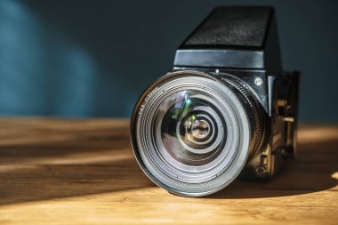 Masanın üzerinde kamera var. Boş bir arkaplanda orta formatta analog film kamerası. Retro vintage teknoloji tarzı. Yüksek kalite fotoğraf