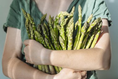 Kuşkonmaz. Elinde taze kuşkonmaz tutan vejetaryen kız. Sulu, sağlıklı çiftlik kuşkonmazı, ekolojik tarım sebzeleri konsepti. Yüksek kalite fotoğraf