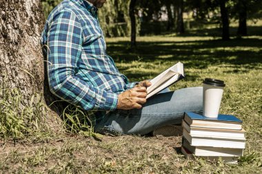 Kitap okuyordum. Genç bir adam kitap ya da ders kitabı okur. Eğitim, eğlence, iş konsepti. Yüksek kalite fotoğraf