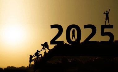 2025 yıllık konsept. Doğadaki aktif insanların siluetleri günbatımının ve 2025 sayısının arkaplanına karşı. Yüksek kalite fotoğraf