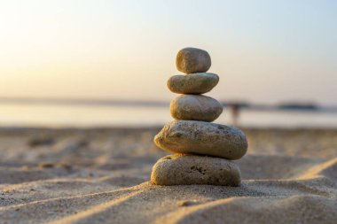 Zen taşları arka plan. Sahilde günbatımının arka planında taş piramidi. Rahatla, denge, sakinlik, konsept. Yüksek kalite fotoğraf