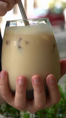 Yazlık bir kafede masanın üstünde buzlu kahve. Yazlık kafe ve soğuk içecek. Dikey video. Yüksek kaliteli FullHD görüntüler