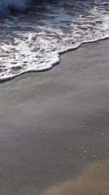 Kumsal, dalgalar, deniz suyu. Dikey video. Yüksek kaliteli FullHD görüntüler