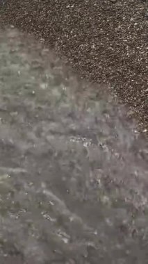 Kumsal, dalgalar, deniz suyu. Dikey video. Yüksek kaliteli FullHD görüntüler