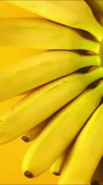 Renkli arka planda dönen muzlar. Yemek tasarımı az yaratıcı bir konsept. Yüksek kaliteli FullHD görüntüler