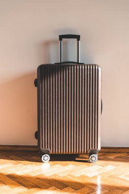 Güneşli bir günde seyahat ve tatil için ışık duvarına yaslanmış bavul. Yüksek kalite fotoğraf