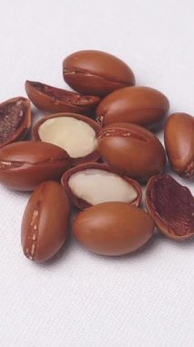 Argan tohumları beyaz arka planda dönüyor. Kozmetik ve ilaç için Argan yağı. Yüksek kaliteli FullHD görüntüler