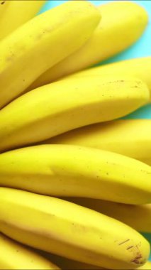 Renkli arka planda dönen muzlar. Yemek tasarımı az yaratıcı bir konsept. Yüksek kaliteli FullHD görüntüler