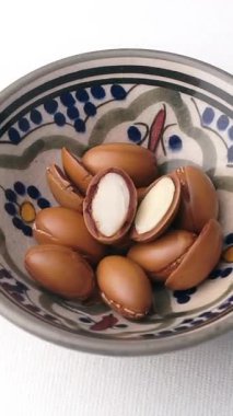 Beyaz arka planda dönen Argan fındıkları. Yüksek kaliteli FullHD görüntüler