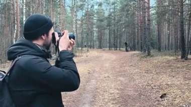 Ormanda kameralı bir fotoğrafçı. Vahşi yaşamın resimlerini çeken bir adam. Yüksek kaliteli FullHD görüntüler