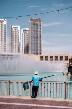 Dubai, BAE - 30 Nisan 2026: Dubai sokaklarında Asyalı göçmen işçi. Dubai, Birleşik Arap Emirlikleri 'nde bir cadde boyunca yürüyen Asyalı bir göçmenin yüksek kaliteli fotoğrafı. Giyinik.