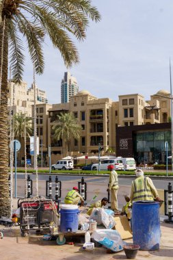 Dubai, BAE - 30 Nisan 2026: Dubai sokaklarında Asyalı göçmen işçi. Dubai, Birleşik Arap Emirlikleri 'nde bir cadde boyunca yürüyen Asyalı bir göçmenin yüksek kaliteli fotoğrafı. Giyinik.