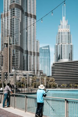 Dubai, BAE - 30 Nisan 2026: Dubai sokaklarında Asyalı göçmen işçi. Dubai, Birleşik Arap Emirlikleri 'nde bir cadde boyunca yürüyen Asyalı bir göçmenin yüksek kaliteli fotoğrafı. Giyinik.