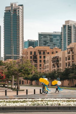 Dubai, BAE - 30 Nisan 2025: Dubai sokaklarındaki Asyalı göçmen işçi. Dubai, Birleşik Arap Emirlikleri 'nde bir cadde boyunca yürüyen Asyalı bir göçmenin yüksek kaliteli fotoğrafı. Giyinik.