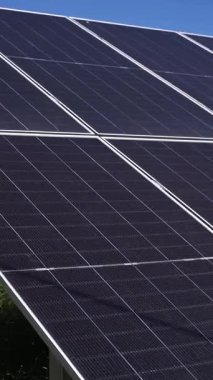 Yaz boyunca güneşli bir kırsal alana monte edilmiş güneş panellerinin havadan veya yerden çekilmiş görüntüleri. Video, yenilenebilir enerjinin gücünü ve güneş teknolojisinin
