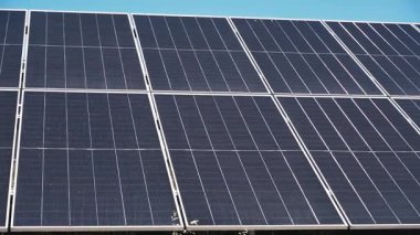 Yaz boyunca güneşli bir kırsal alana monte edilmiş güneş panellerinin havadan veya yerden çekilmiş görüntüleri. Video, yenilenebilir enerjinin gücünü ve güneş teknolojisinin