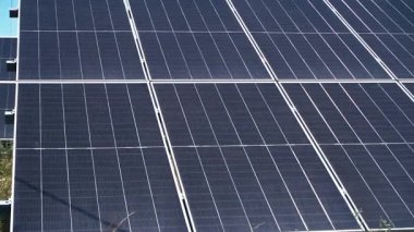 Yaz boyunca güneşli bir kırsal alana monte edilmiş güneş panellerinin havadan veya yerden çekilmiş görüntüleri. Video, yenilenebilir enerjinin gücünü ve güneş teknolojisinin