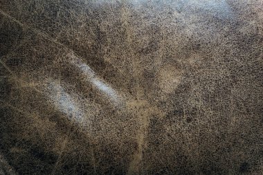 Görünür çatlaklar ve doğal aşınmalarla eski kahverengi deri dokuların yakın çekimi. Tasarım projeleri, döşeme kataloğu veya deri kataloglarında kullanım için ideal arkaplan, materyal referansı veya yüzey ayrıntısı